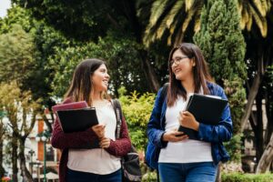 two women on campus talking and walking together