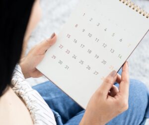 a woman looking at a calendar trying to calculate pregnancy due date